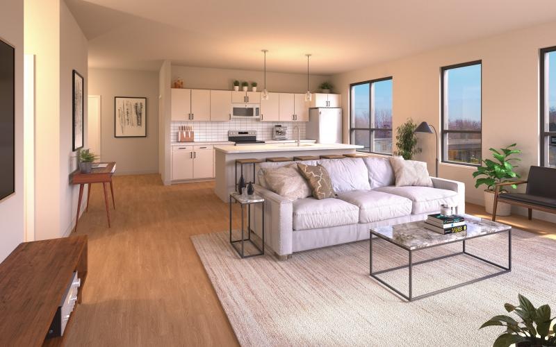a living room with a couch and a table with a kitchen in view